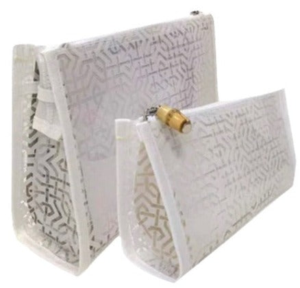 Two white TRVL Bag Lattice Collection purses with pattern detailing, displayed from different angles against a light background, featuring natural bamboo pullers.
