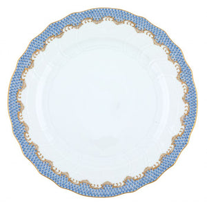 A white ceramic plate with a decorative scalloped edge, featuring a blue and gold patterned border, evokes artistic appreciation reminiscent of the Herend Fish Scale Light Blue Collection by Herend.