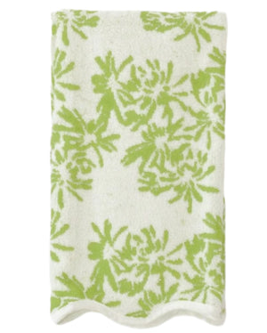 A folded white towel with a green floral design and scallop trim from the Weezie Towels x Meg Braff Bath Collection evokes a Palm Beach summer.