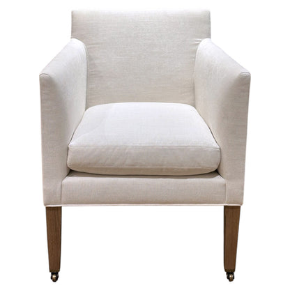 The Lee Industries Arm Chair on Casters features cream upholstery, a cushioned seat, straight arms, and wooden legs for comfort and style, shown in a front-facing photo.