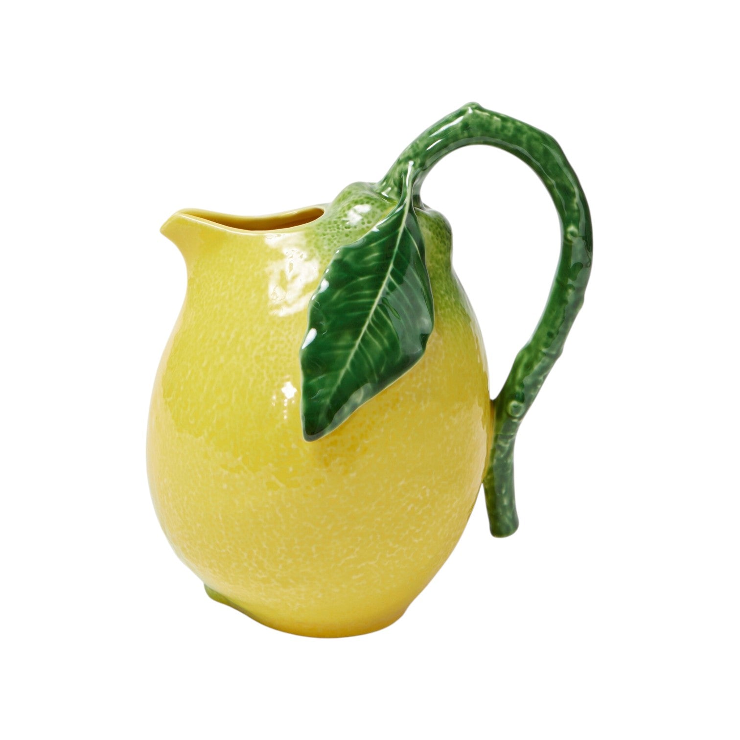 The Lemon Collection by Bordallo Pinheiro features a ceramic pitcher shaped like a yellow lemon with a green leaf and stem handle, creating a whimsical citrus accent for any table. Shown against a white background.