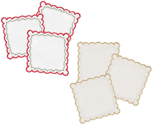 The Kim Seybert Arches Cocktail Napkin Set includes two sets of four white linen napkins with scalloped designs: one features red and green embroidered geometric edges, while the other has elegant gold edges.