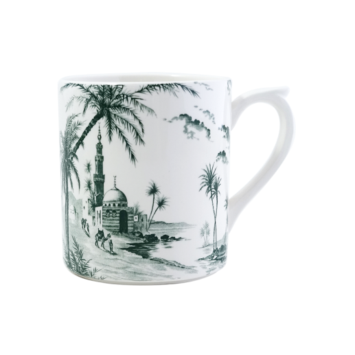 The Depareillees Vert Dinnerware and Serveware Collection by Gien France features a white ceramic mug with iconic black and white illustrations of palm trees, a domed mosque, minaret, and nearby figures—perfect for your unique collection or table.
