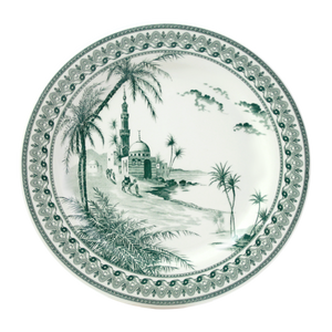 The Depareillees Vert Dinnerware and Serveware Collection by Gien France features a round ceramic plate with a decorative border, illustrated with palm trees, people, and a mosque motif—an elegant accent for any table.