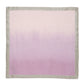 The Kim Seybert Dip Dye Napkin Set features square fabric that transitions from light pink to lavender, accented by a thin gray edge, evoking autumn hues.