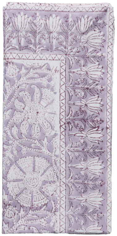 A folded fabric napkin from the Kim Seybert Provence Napkin Set features a detailed lavender and white floral and geometric block print, ideal for mixing with a matching tablecloth or other Provence Napkins for a cohesive, playful table setting.