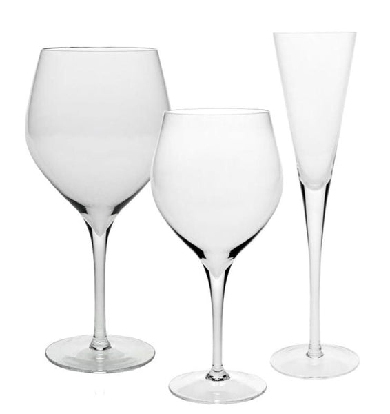 Three distinct styles of empty glasses: a large balloon wine glass on the left, a smaller wine glass in the center, and a tall, slender champagne flute on the right—all showcasing fine rims and transparent stems reminiscent of the William Yeoward Crystal Lillian Collection by William Yeoward Crystal.