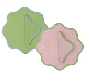 The Duggan Society Daisy Table Linen Collection features two elegant scalloped-edge placemats—green with blue trim and pink with green trim—each paired with a hand-dyed linen napkin for a refined setting.