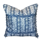 The Little Zanzibar Down Pillow by Hive Custom Pillows features a square blue 22x22 design with white botanical patterns and small white pom-poms along the edges, displayed against a white background. This handmade pillow is perfect for adding a charming touch to any room.