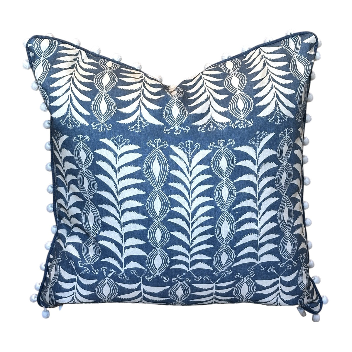 The Little Zanzibar Down Pillow by Hive Custom Pillows features a square blue 22x22 design with white botanical patterns and small white pom-poms along the edges, displayed against a white background. This handmade pillow is perfect for adding a charming touch to any room.