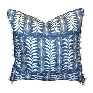 The Little Zanzibar Down Pillow by Hive Custom Pillows features a square blue 22x22 design with white botanical patterns and small white pom-poms along the edges, displayed against a white background. This handmade pillow is perfect for adding a charming touch to any room.