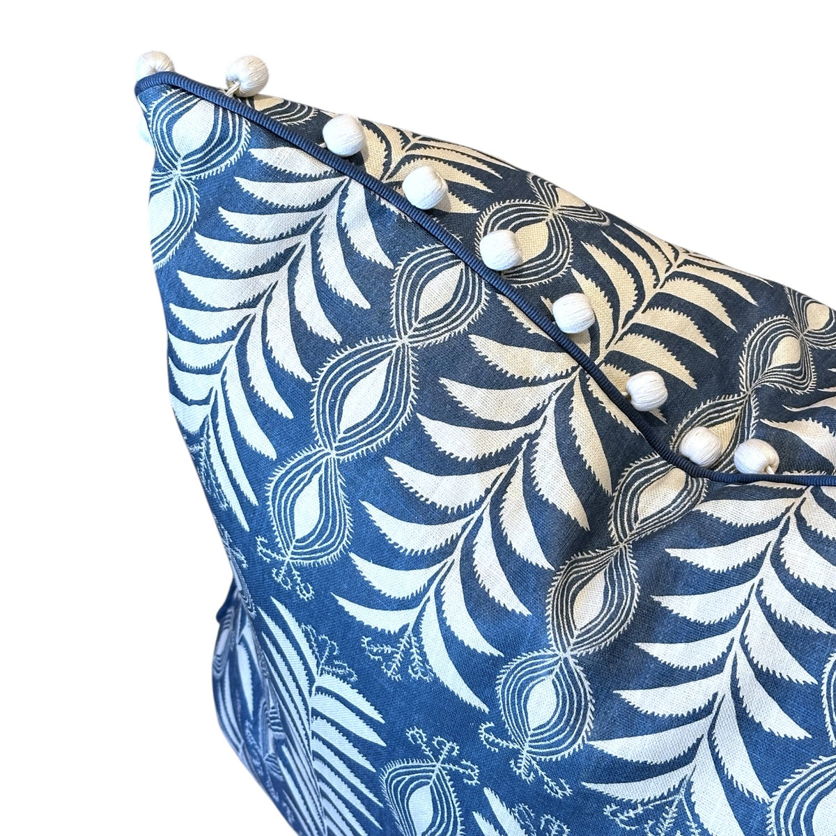 The Little Zanzibar Down Pillow by Hive Custom Pillows is a charming handmade accent for your space, featuring a blue cover with a white fern-like pattern and small white pom-pom trim along the edge. This 22x22 pillow adds decorative flair to any room.