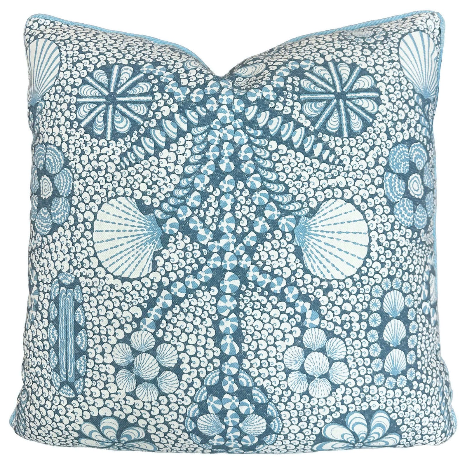 The Shell Grotto Seaside Outdoor Pillow by Associated Design features blue and white geometric and floral patterns, expertly crafted for durability and style, making it a standout accent against any crisp white background.