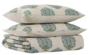 A pair of beige pillows and a folded quilt from the John Robshaw Vani Leaf King Duvet Set, all adorned with a blue and green floral pattern inspired by Rajasthan palace bedding, displayed against a white background.