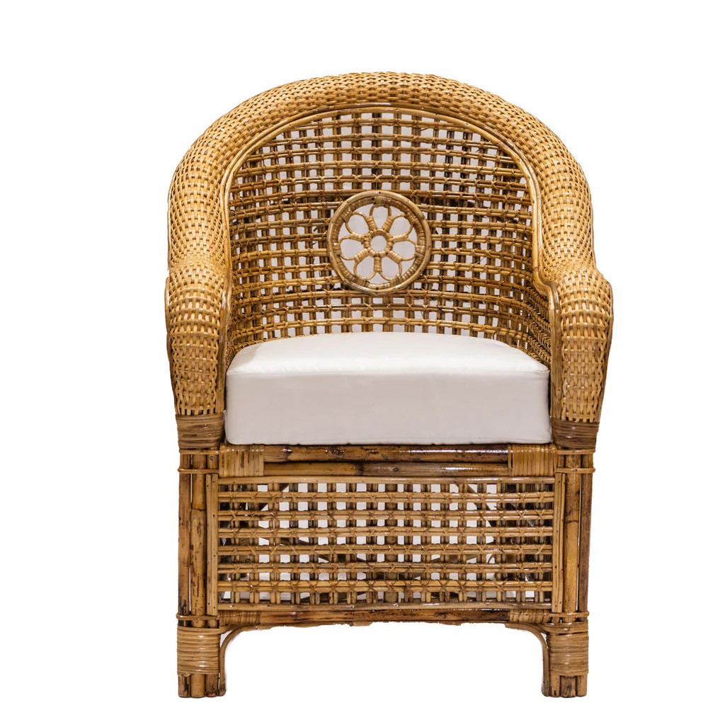 The Julianna Occasional Chair by Varnish Collection features a rounded back and armrests, natural wicker construction, a white seat cushion, and a circular decorative pattern at the center of the backrest.