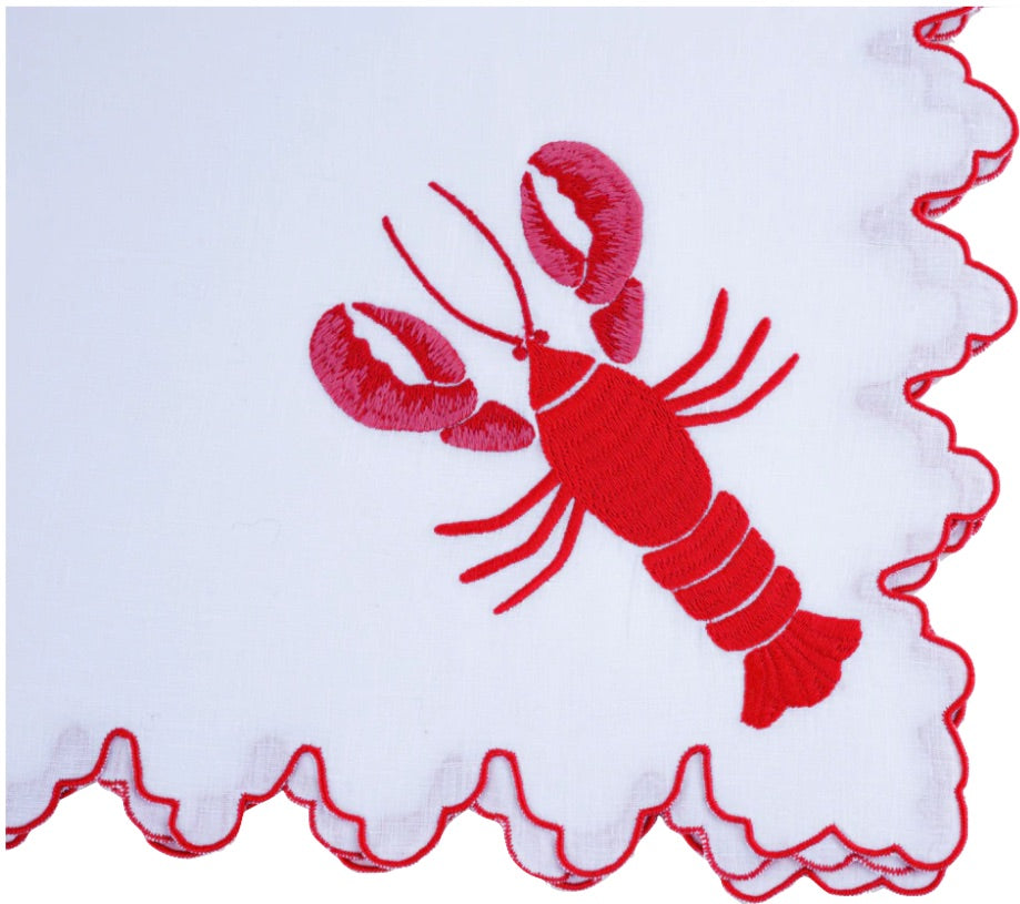 Haute Home’s Red Lobster Napkin Set features white linen napkins with scalloped red edges and an embroidered red lobster in one corner—ideal for seafood dinners.