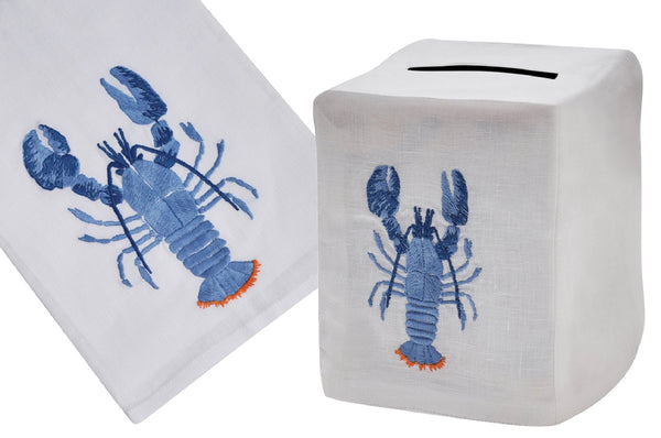 Two items hand embroidered with the Lobster Collection, Blue with Orange Tail: a flat white tip towel and a white square money bank with a slot on top by Haute Home.