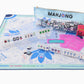 The Oh My Mahjong Mat Collection includes tiles, racks, a neoprene non-slip playmat, instructions, and a scorecard—all organized in an Oh My Mahjong branded zipper pouch.