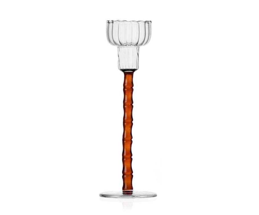 Part of the Rivoli Drinkware and Tealight Collection by Ichendorf Milano, this hand-crafted glass tealight holder features a clear ribbed round cup and tall, textured amber stem—an elegant accent against a white background.