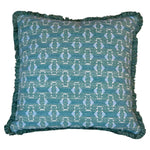 The Teal Sicily Outdoor Pillow by Associated Design features a blue geometric pattern with light blue and white accents and fringed edges, crafted from premium materials for a luxurious touch.