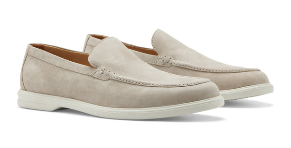 A pair of Peter Millar Excursionist Venetian Loafers in beige water-resistant suede with white soles on a white background.