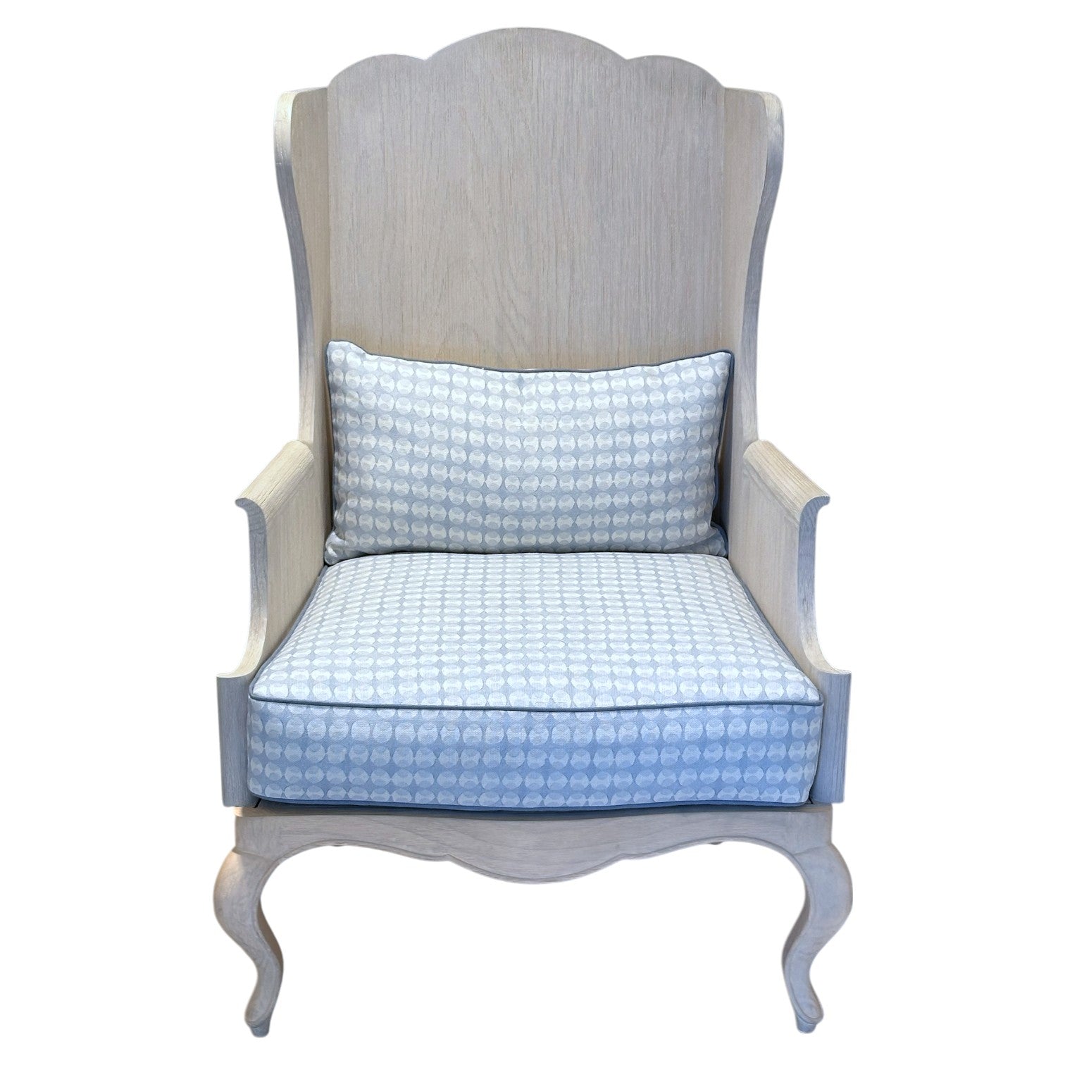 The Luberon Chair by Mr Brown features light wood, curved legs, a high back, and blue patterned cushions for French country flair, shown from the front against a white background.