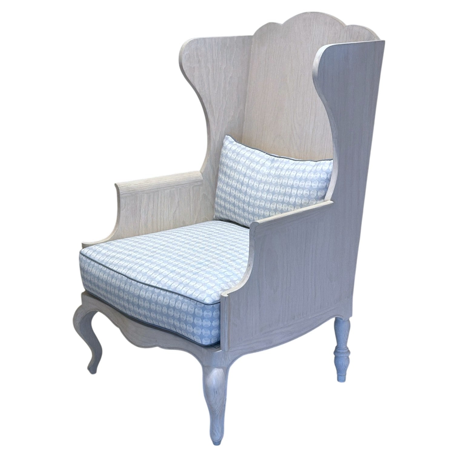 The Luberon Chair by Mr Brown features a high-back French country style with curved armrests, a light wood finish, and blue patterned seat and back cushions.