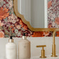 A minimalist L’Avant Collective Lucite Soap & Candle Tray holding a white bottle of hand lotion and a beige bottle of hand soap on a bathroom vanity beside a gold faucet.