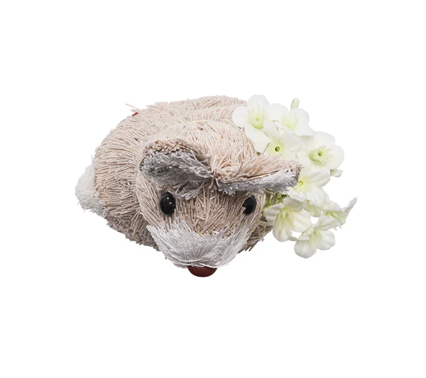 The Kim Seybert Easter Bunny Napkin Ring, a small beige bunny with black eyes, is shown beside white artificial flowers on a pristine background, creating a charming festive accent for your spring decor.