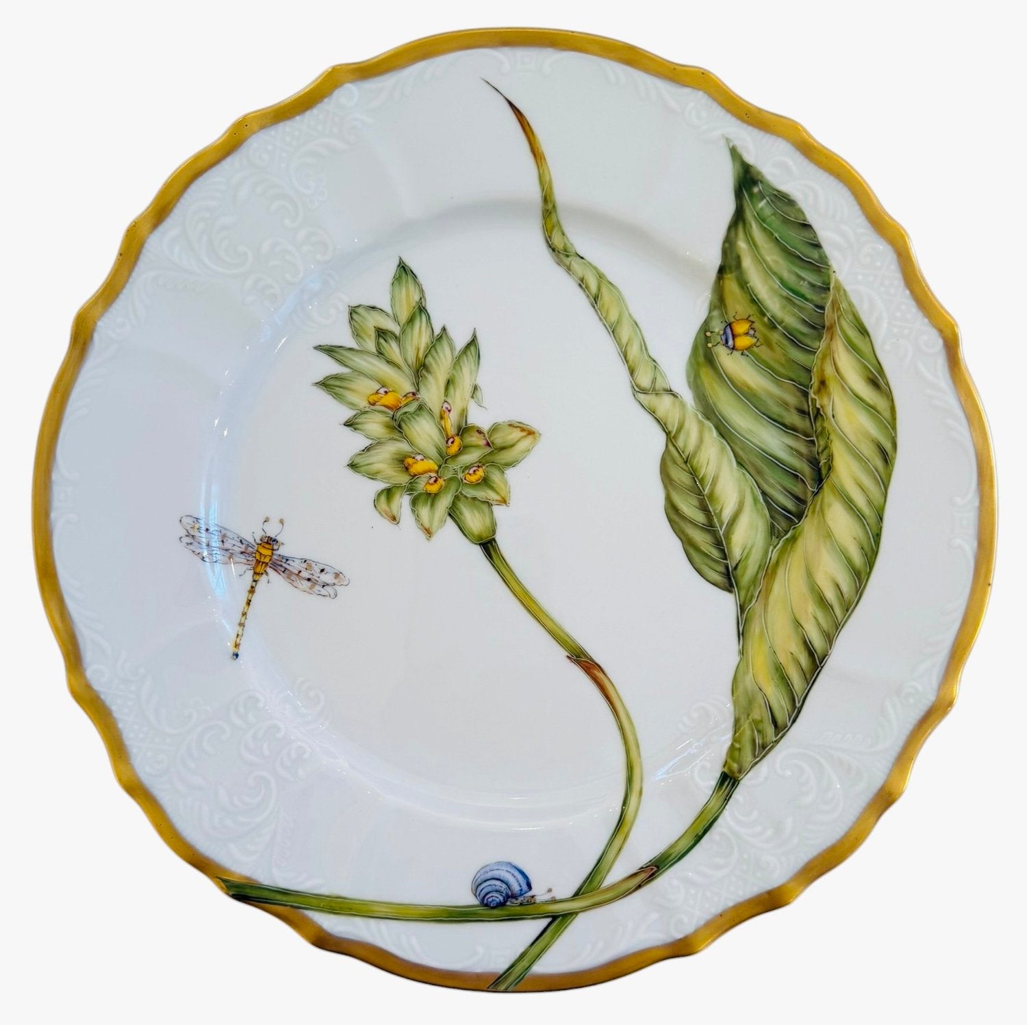 The Elegant Foilage Dinner Plate Collection by Anna Weatherley features a limited edition hand-painted porcelain plate with a yellow rim and delicate leaves, flowers, a dragonfly, snail, and small insects on white.