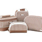 Four brown and white patterned bags from the Stephanie Johnson Marbella Mocha Travel Collection—including a stylish makeup bag and a compact mini pouch—are arranged together on a white background.