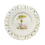 A fine bone china plate from Duggan Society's Marina Palms Dinnerware Collection, featuring a palm tree with pink and blue foliage and a green-gold border, adds coastal elegance to any table.
