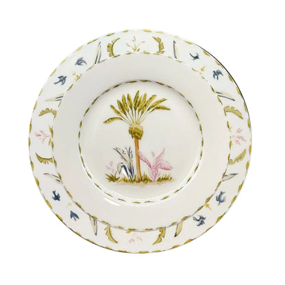 A fine bone china plate from Duggan Society's Marina Palms Dinnerware Collection, featuring a palm tree with pink and blue foliage and a green-gold border, adds coastal elegance to any table.