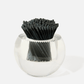 The Acrylic Match Striker Collection by Tart by Taylor features a clear acrylic holder filled with neatly arranged black-tipped, black-stemmed matches—an elegant accent for your coffee table.