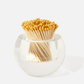 The Acrylic Match Striker Collection by Tart by Taylor features a clear glass container with yellow-tipped matches, arranged in a fan shape for a chic coffee table accent and functional match striker.