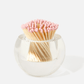 The Acrylic Match Striker Collection by Tart by Taylor features a clear, round glass container filled with pink-tipped wooden matches—an elegant accent that complements any coffee table and pairs perfectly with an acrylic match strike or included strike pad.