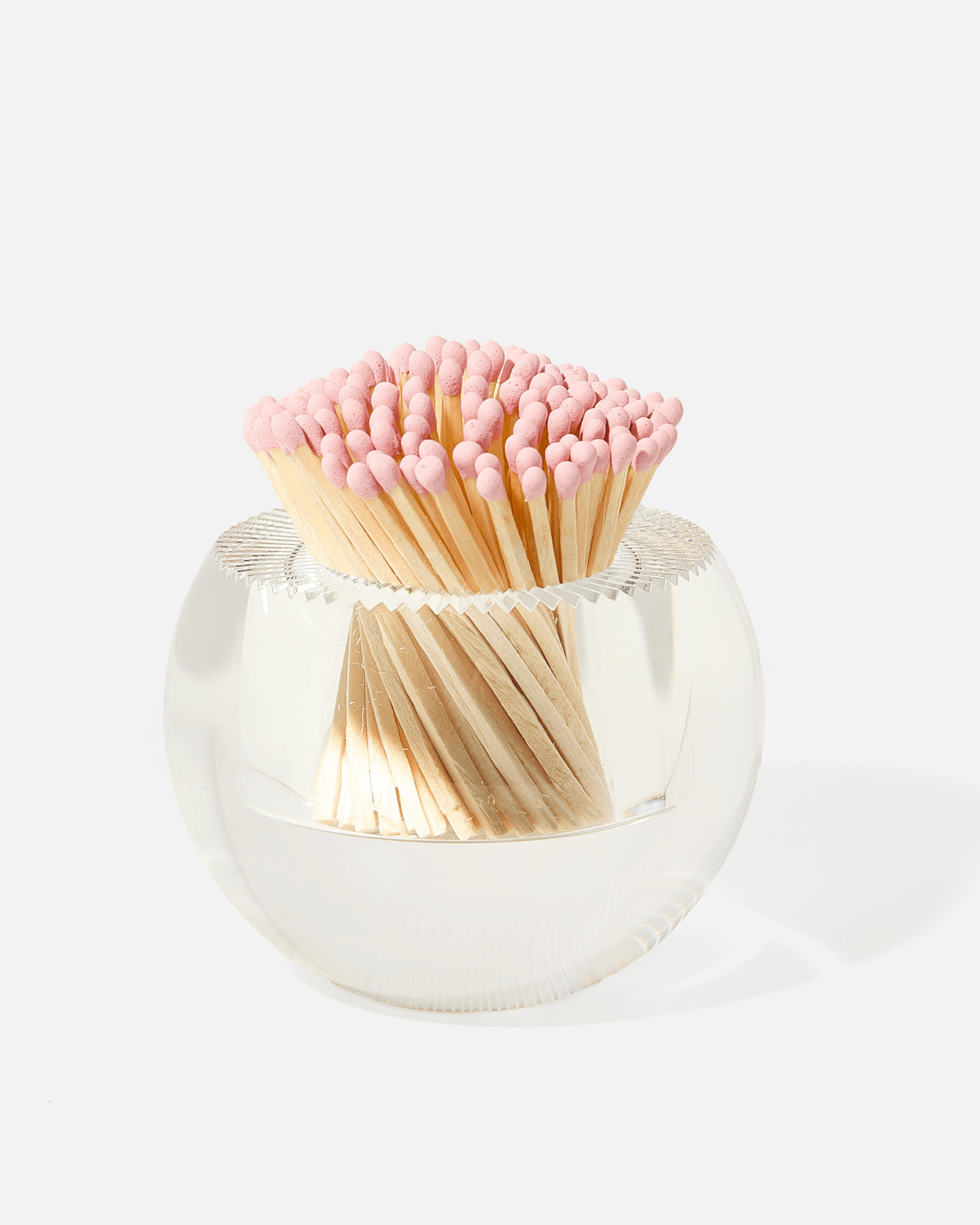 The Acrylic Match Striker Collection by Tart by Taylor features a clear, round glass container filled with pink-tipped wooden matches—an elegant accent that complements any coffee table and pairs perfectly with an acrylic match strike or included strike pad.