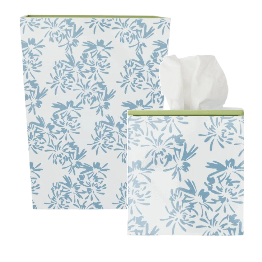 The Weezie Towels x Meg Braff Cornflower Bath Accessories feature two decorative rectangular containers with a blue floral pattern on white; one holds tissues partially pulled out, while the other remains empty, both adding Palm Beach charm.