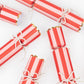 Meri Meri Pearl Bow Crackers feature red and white stripes, gold scalloped edges, and pearl bows—perfect festive table decorations for Christmas, beautifully arranged on a white background.