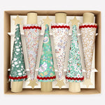 Meri Meri Liberty Tree Crackers: six tree-shaped party crackers in various floral and star-patterned paper designs, each topped with a gold star, arranged in a cardboard tray.