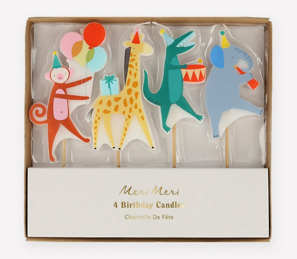 A box of Meri Meri Themed Candles containing four birthday party candles shaped like colorful animals: a pink monkey, a yellow giraffe, a blue elephant, and a white unicorn.