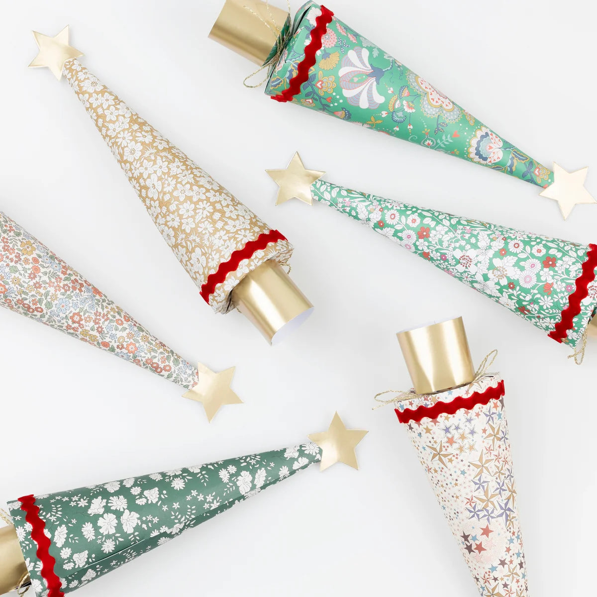 Six Meri Meri Liberty Tree Crackers featuring floral and star patterns, finished with red trim and gold star toppers.
