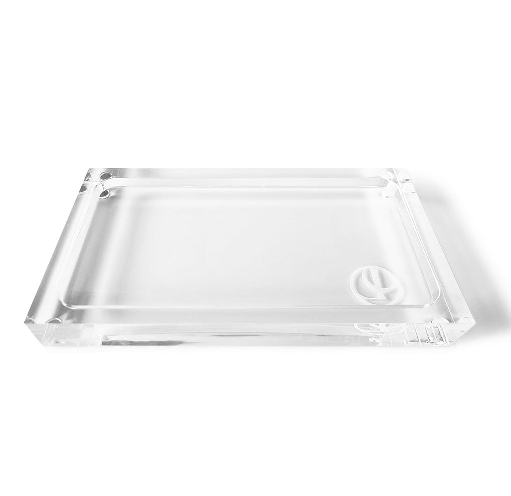 Minimalist Lucite Soap & Candle Tray Collection tray made of acrylic with a circular logo embossed in the bottom corner.