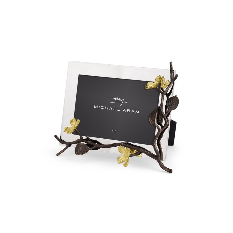 The Michael Aram Dogwood Frame is a rectangular handcrafted photo frame featuring a goldtone metallic branch and yellow flower design, adding unique elegance and style to your décor.
