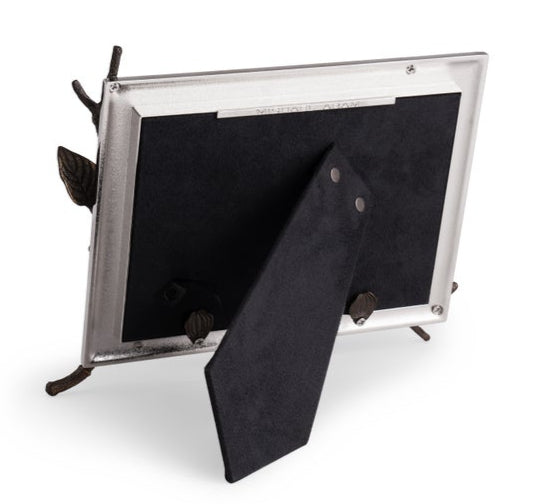 The Michael Aram Dogwood Frame features a goldtone finish, black velvet back and stand, and is supported by metal branches, shown here from the rear.