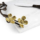 The Michael Aram Dogwood Serveware Collection features a marble cheese board with a nature-inspired design, decorative metallic branch accents with two gold flowers, and a handcrafted stainless steel cheese knife.