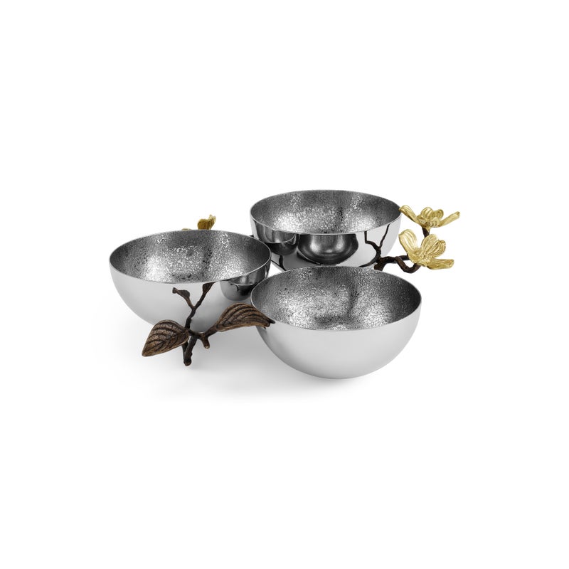 Three silver bowls are connected by a decorative branch with bronze leaves and gold flowers, reflecting the nature-inspired Dogwood Serveware Collection by Michael Aram. Handcrafted stainless steel gives this elegant set a sophisticated touch.