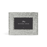 The Hammertone Frame by Michael Aram is a silver, textured rectangular photo frame featuring a refined hammertone metal finish and a black inner label displaying the “Michael Aram” signature in white text, designed to hold a 4x6 photo.
