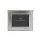 The Michael Aram Hammertone Frame is a square picture frame crafted from hammered metal, showcasing a distinctive hammertone texture and featuring a dark insert with “Michael Aram” printed in white at the center.