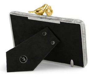 The Michael Aram Lovebirds Frame is a handcrafted picture frame featuring silver edges, a black back, a stand, and two gold bird accents on top.